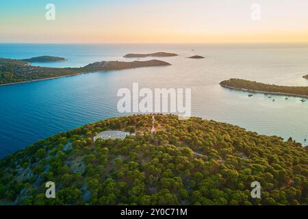 Panoramablick auf die Inseln in der Adria und das Heckenlabyrinth zwischen Waldbäumen bei Sonnenuntergang. Lavendellabyrinth in Rogoznica, Kroatien. Luftaufnahme von coasta Stockfoto