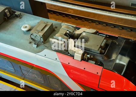 Ansicht des Dachs des neuen roten und grauen Elektrozugs mit Belüftungssystem. Nahaufnahme der Lokomotive am Bahnhof. Eisenbahnverkehr Stockfoto
