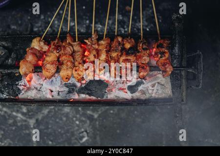 Der Prozess der traditionellen Herstellung von indonesischem Hühnersatay mit Holzkohle und leckerer asiatischer Küche. Stockfoto