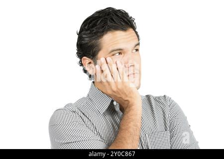 Porträt eines ernsten, besorgten latino-Mannes in legeren Kleidern, schröpfendes Kinn, Kopf in Hand, der wegschaut auf einen leeren Kopierraum, imaginär eingefügter Profi Stockfoto