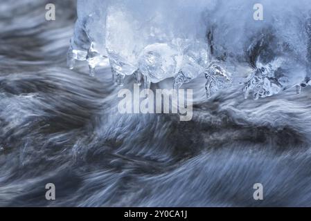 Eiszapfen haben sich auf einem Stein in einem Bach gebildet Stockfoto