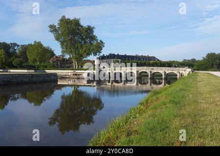 Malerische Landschaft mit Fluss und Steinbogenbrücke, umgeben von grünen Bäumen und Wiesen unter blauem Himmel, Brücke, Schloss Chambord, Chateau de CH Stockfoto