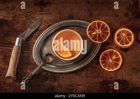 Orangentee mit frischen und getrockneten Orangen auf einem Vintage-Tablett auf einem dunklen rustikalen hölzernen Hintergrund, von oben aufgenommen, Lebensmittelfotografie, Lebensmittelfotografie Stockfoto