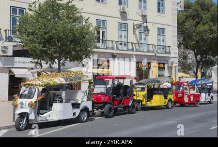 Reihe farbenfroher Tuk-Tuks auf einer Stadtstraße vor einem Gebäude bei sonnigem Wetter, Lissabon, Lisboa, Portugal, Europa Stockfoto