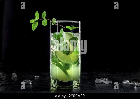 Mojito-Cocktail. Kaltes Sommergetränk mit Limette, frischen Minzblättern und Eis. Kühles Getränk auf schwarzem Hintergrund, Lebensmittelfotografie Stockfoto