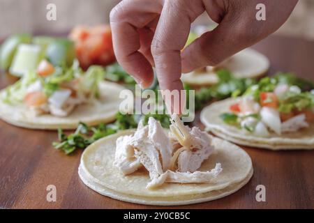 Hühnerstücke auf einen kleinen Straßentako auf ein Holzbrett legen Stockfoto