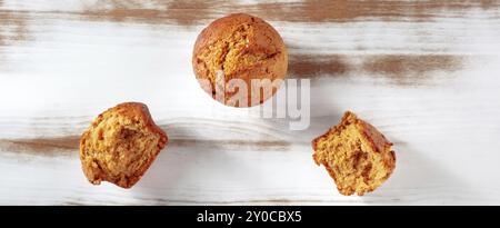 Gebrochene orange Muffins auf einem rustikalen hölzernen Küchentisch Panorama, einfaches Backen, flache Lay Shot über dem Kopf mit Kopierraum, Lebensmittelfotografie Stockfoto