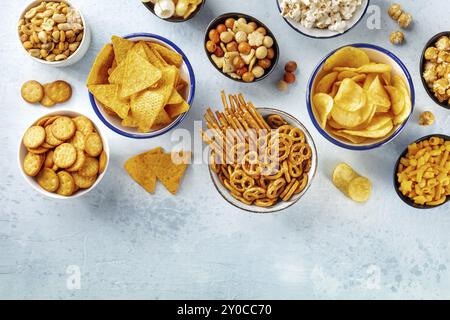 Salzige Snacks, Party-Mix, Overhead-Flat-Lay-Shot mit Kopierplatz. Eine Auswahl an Vorspeisen, von oben geschossen. Tortilla und Kartoffelchips, Cracker, po Stockfoto