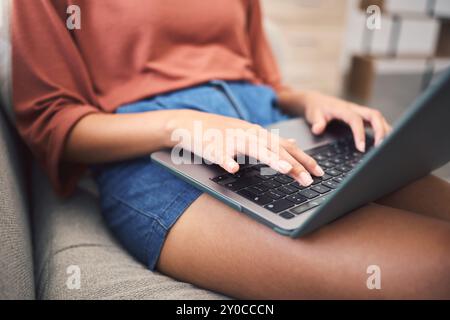 Frau, Hände und Heim-Laptop für Fernarbeit, arbeitender Mitarbeiter und Texter-Redakteur auf dem Sofa. Weibliche Person, E-Mail-Kunde und Lektüre der Bewertung Stockfoto