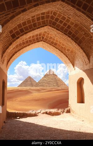 Der alte Bogen am Eingang zu den Großen Pyramiden in Gizeh Pyramidenkomplex (Gizeh Nekropolis), Ägypten. Blick auf Sanddünen und Pyramiden von Chephren und Cheops Th Stockfoto