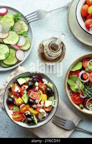 Frische vegetarische Salate, Overhead Flat Lay Shot einer Auswahl. Auswahl an Tellern und Schüsseln mit grünem Gemüse. Gesundes Essen, mit Olivenöl Stockfoto