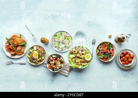 Frische Salate, Overhead Flat Lay Shot einer Auswahl. Auswahl an Tellern und Schüsseln mit grünem Gemüse. Gesundes Essen, Top-Shot, mit Kopierraum Stockfoto