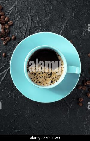 Teal Kaffeetasse und Kaffeebohnen, Top Shot auf schwarzem Hintergrund mit Kopierraum, Lebensmittelfotografie Stockfoto