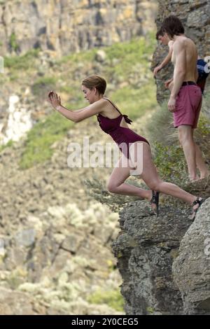 Eine junge Frau springt von einer Klippe ins Wasser in Twin Falls, Idaho Stockfoto