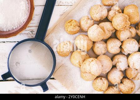 Nahaufnahme von castagnole, typisch italienische Karneval süß mit Puderzucker und Sieb von oben gesehen Stockfoto