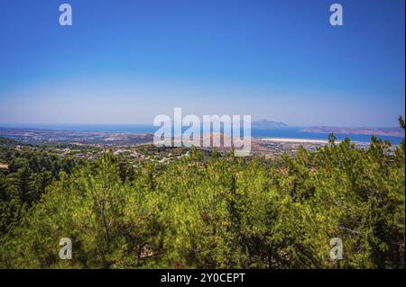 Panorama mit Bergen, dicht bewaldeten grünen Hügeln und blauem Meer unter einem hellblauen Himmel, Zia, Insel Kos, Griechenland, Europa Stockfoto