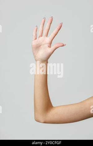 Frauenarm verlängert mit schwarz-weißem Nagellack Stockfoto