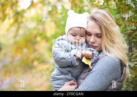 Happy Family im Freien. Mutter und ihre kleine Tochter spielen, kuscheln sich Herbst Spaziergang in der Natur im Freien Stockfoto