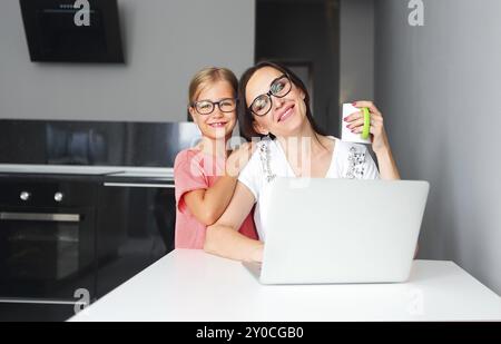 Beschäftigte Mutter von zu Hause aus arbeiten mit kleinen Tochter Stockfoto