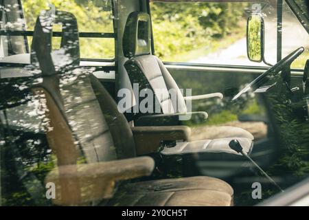 Fahrerposition eines alten Oldtimer-Van. Großes Kunststofflenkrad und Kapitänssitze, sichtbar in einem Van aus den 80er Jahren Ansicht Lenkrad, Bedienelemente, Stockfoto