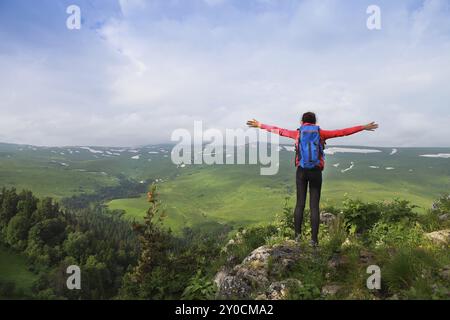 Wanderer mit Rucksack auf einem Berg entspannen und genießen Talblick bei Sonnenaufgang Stockfoto