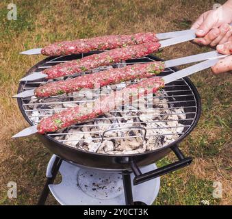 Ein Koch, rotes Fleisch Schaschlik auf einem Holzkohlegrill Stockfoto