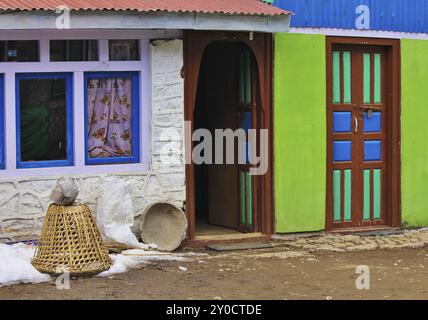 Farbenfrohe lackierte Türen und Fassade. Geflochtene Hülse für den Transport von Gütern. Szene in Nepal Stockfoto