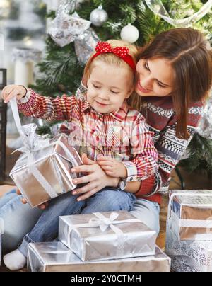 Zwei glückliche Schwestern Eröffnung Weihnachten präsentiert den Weihnachtsbaum zu sitzen Stockfoto