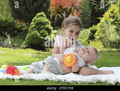 Zwei spielende kleine Schwestern im Sommergarten Stockfoto