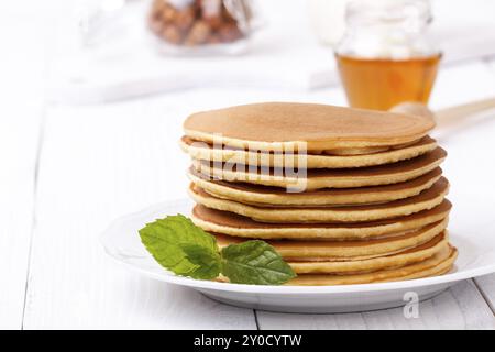 Amerikanische Pfannkuchen mit Früchten und Ahornsirup weiß Holz- hintergrund Family Mit Frühstück Snack stack serviert. Stockfoto