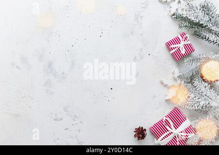 Weihnachten, Neujahr grau Beton flach legen. Rot weiß gestreifte Geschenkschachteln Draufsicht. Geschenkband und Verpackungspapier. Weihnachtsbaum Tanne, Zapfen, Stockfoto