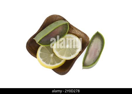 Aloe Vera Blatt- und Zitronenscheiben in einer Holzplatte isoliert auf weißem Hintergrund, Draufsicht, natürliche organische Kosmetikzutaten für empfindliche Haut, alt Stockfoto