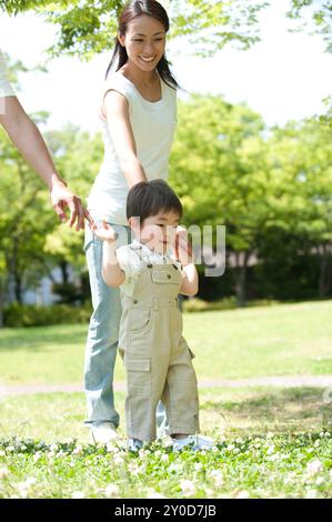 Junge geht Hand in Hand mit Eltern Stockfoto