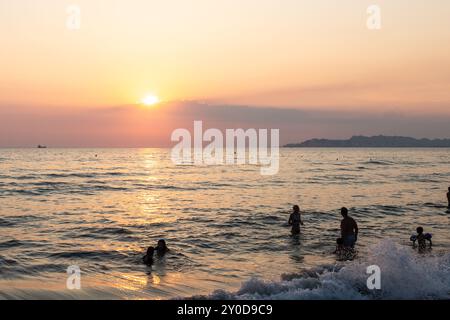 Sonnenuntergang am Strand in der Nähe der Stadt Vlorë in Albanien, die sich an der Bucht von Vlorë ausbreitet und von den Ausläufern der Ceraunischen Berge Ao umgeben ist Stockfoto