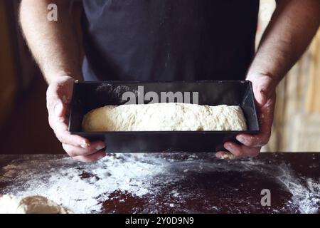 Männliche Hände Form mit frischem Teig auf die Küche. Nahaufnahme Stockfoto