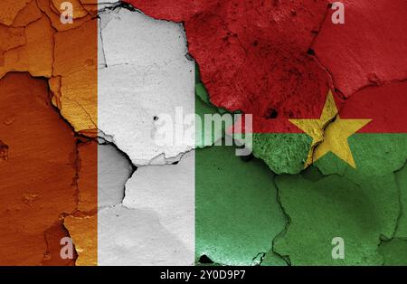 Flaggen von Elfenbeinküste und Burkina Faso auf gerissene Wand gemalt Stockfoto