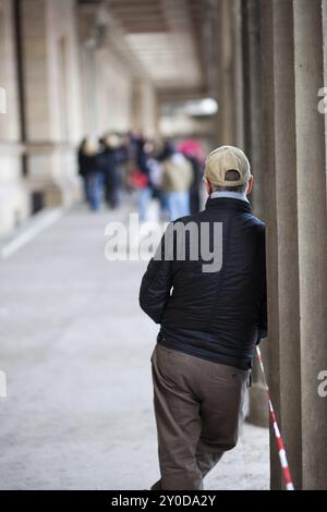 Wartender Mann, der sich an eine Säule lehnt Stockfoto