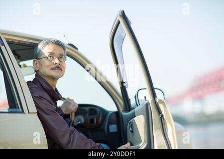 Ein älterer Mann öffnet eine Autotür Stockfoto