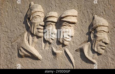 Vier Fischer als Relief in Stein gemeißelt, vier Fischer als Skulptur Stockfoto