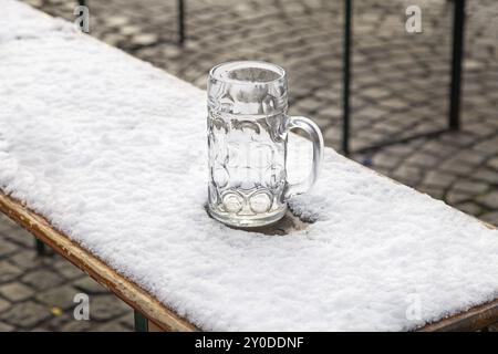 Vergessener Bierkrug im Schnee am Viktualienmarkt in München Stockfoto