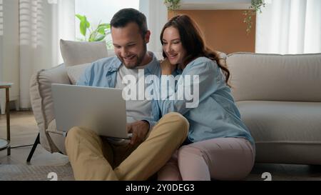 Glückliche Familie Paar Mann Kaukasische Frau Freundin Freund Frau Ehemann Shopping online Laptop mit Computer erregt Gewinn zu Hause Internet Stockfoto