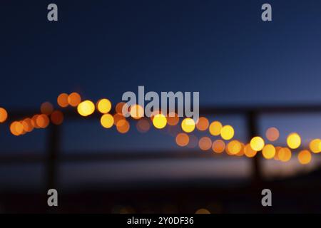 Außerhalb des Fokus weihnachtslichter auf dem Geländer eines Balkons in der Nacht Stockfoto