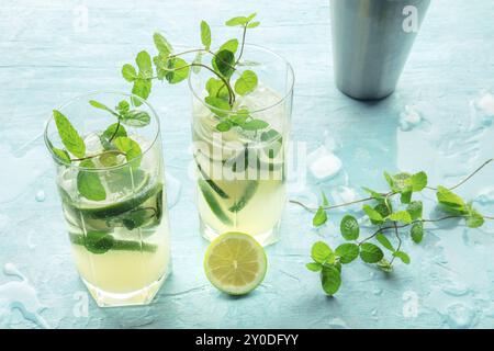 Mojito-Cocktail. Kaltes Sommergetränk mit Limette, frischen Minzblättern und Eis. Kühles Getränk auf blauem Hintergrund, Lebensmittelfotografie, Lebensmittelfotografie Stockfoto