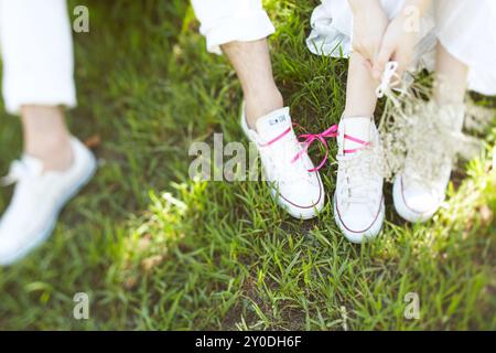 Braut und Bräutigam sitzen auf Rasen Stockfoto