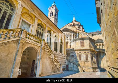 Der mittelalterliche Stein-Visconti-Brunnen und die Basilika Santa Maria Maggiore mit schlanken Säulen, Schnitzereien und hohem Glockenturm, Bergamo, Italien Stockfoto