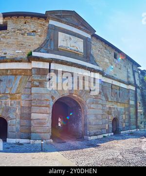 Historisches Steintor Porta Sant'Alessandro mit Wandskulptur des geflügelten venezianischen Löwen in Citta Alta, Bergamo, Italien Stockfoto