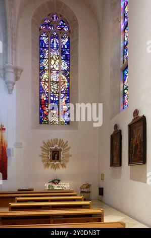 Eisenstadt, Burgenland, Österreich. Römisch-katholische Kathedrale St. Martin. Seitengang mit Heiligenbild und Buntglas Stockfoto