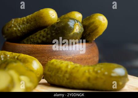 Eingelegte Gurken auf einem Holztisch während des Kochens, salzige und saure eingelegte Gurken mit Gewürzen Stockfoto