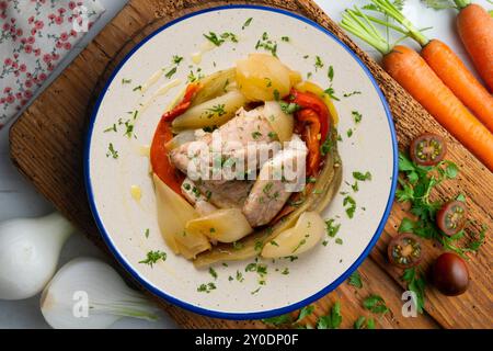 Gebackene Makrele mit Esccalivada-Gemüse, Paprika, Zwiebeln und Auberginen. Tisch mit Draufsicht und Dekoration. Stockfoto