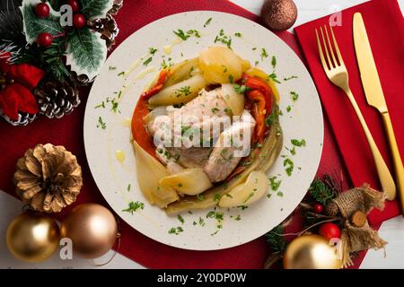 Gebackene Makrele mit Esccalivada-Gemüse, Paprika, Zwiebeln und Auberginen. Tisch mit Panoramablick und Weihnachtsdekoration. Stockfoto